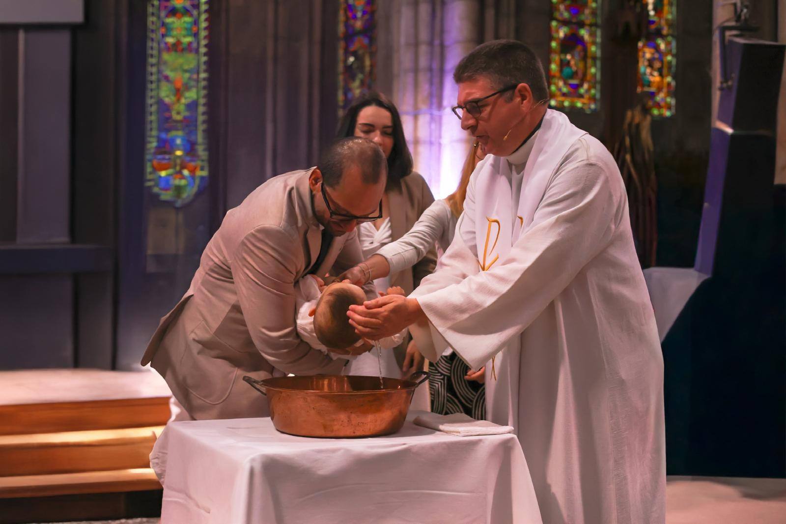 Baptême d’un bébé à l’église, le prêtre versant l’eau sur sa tête